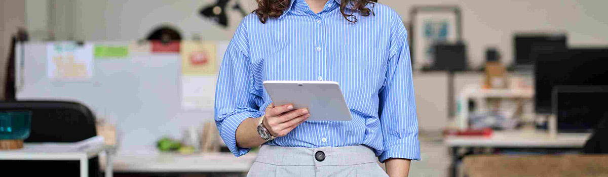 A woman holding an electronic tablet in an office setting.