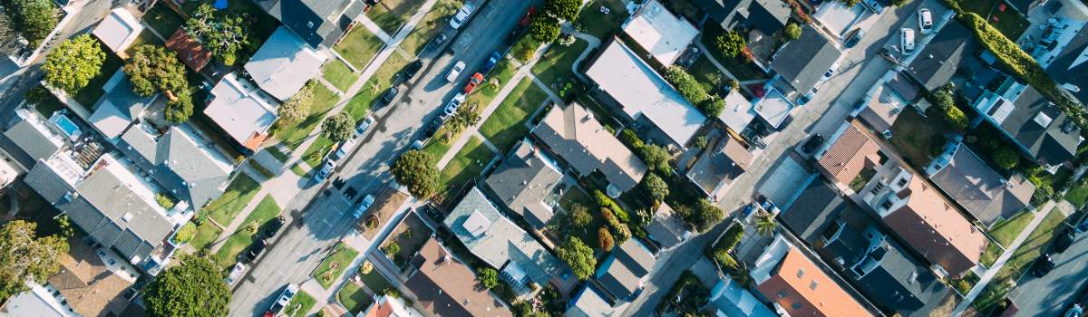 Residential apartment buildings with walkways and trees in between them.