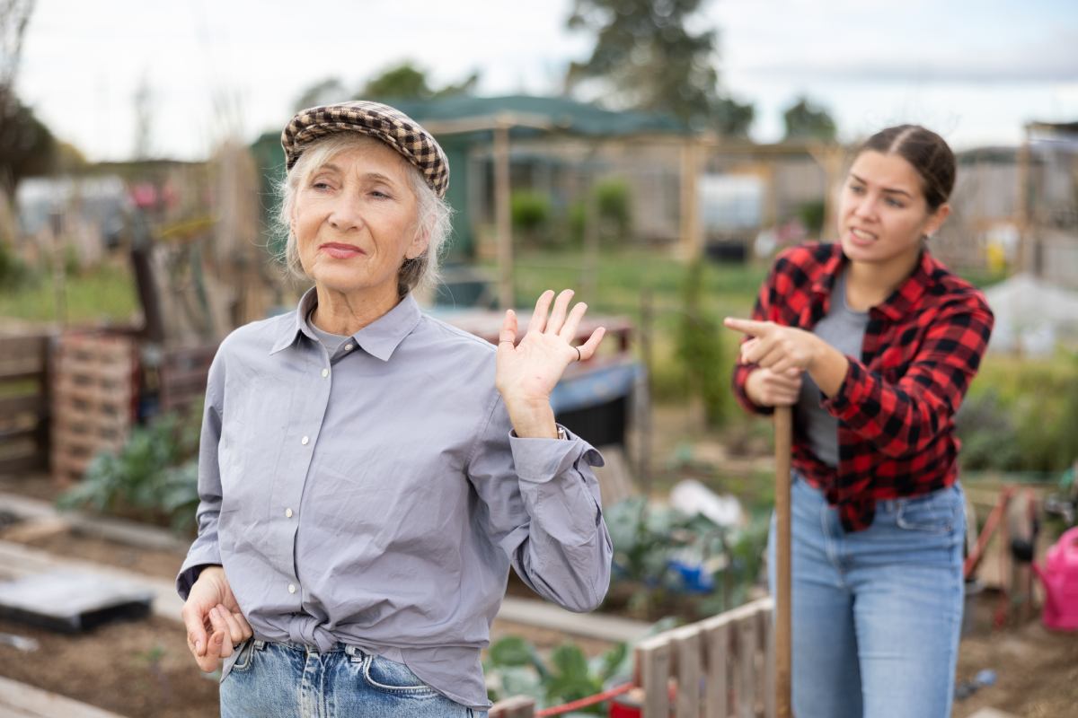 Two angry neighbors argue in a shared community garden plot.