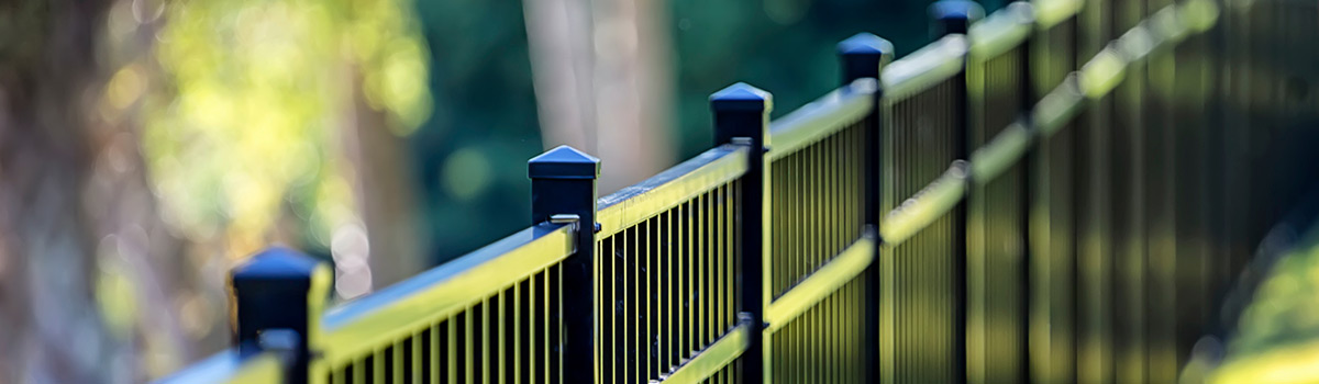 A fence with trees in the background.